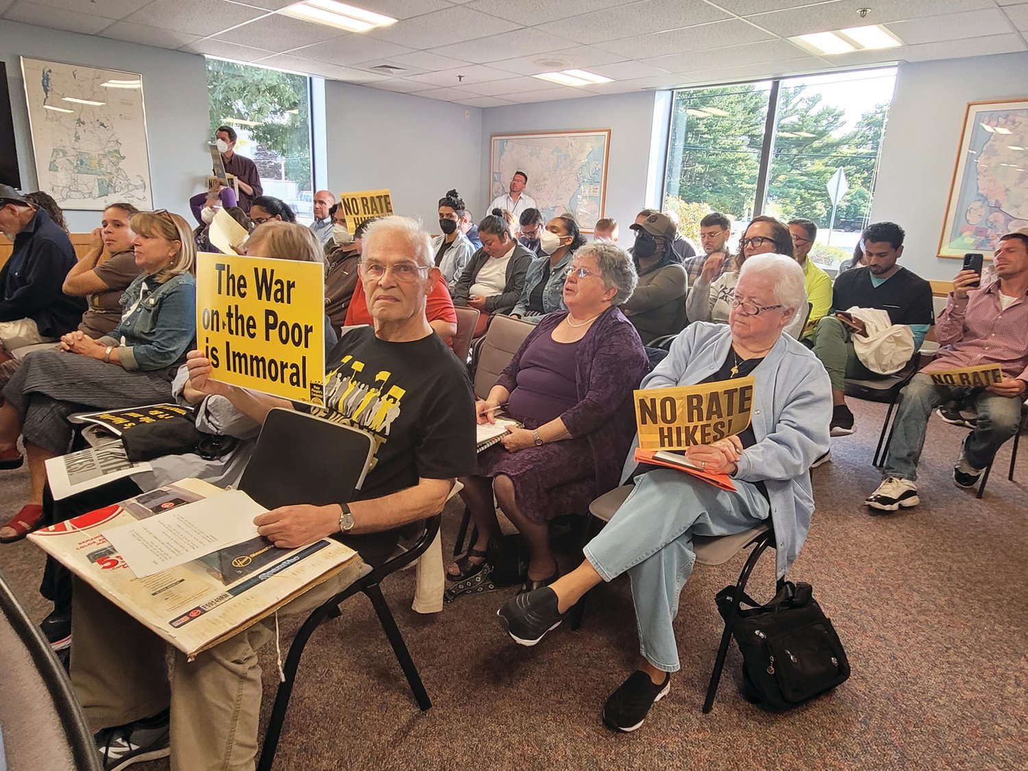 SIGNS OF PROTEST: Attendees at a public hearing on an increase in electricity rates held signs in protest. The hearing was held in Warwick before the state’s Division of Public Utilities and Carriers.